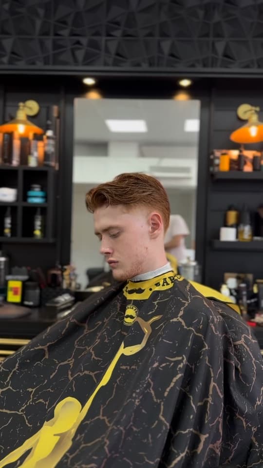 Ginger quiff with a low taper at the sides, front three-quarter view